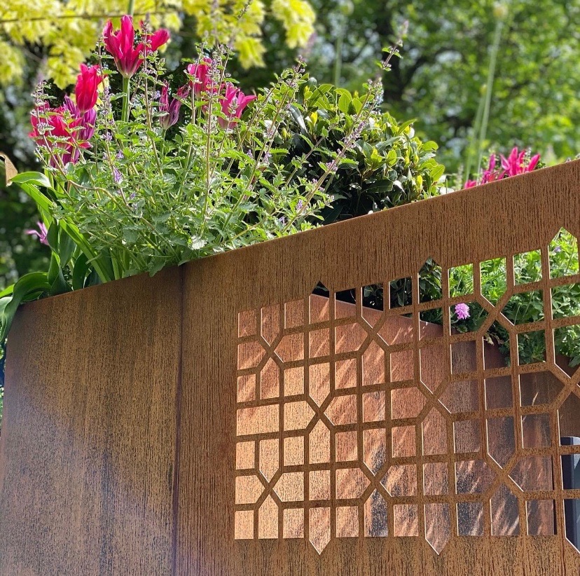 Beautiful flowers overhanging a crafted fence